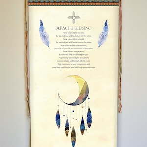 May include: A beige scroll with a Native American blessing printed in black text. The scroll features a blue and yellow crescent moon with feathers hanging from it. The scroll is hanging from a wooden dowel with red and orange tassels.