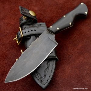 Cuchillo de caza Tercio Cazador con empuñaduras de cuerno de búfalo; espiga completa, punta caída y funda de transporte horizontal. Fabricado en EE. UU.