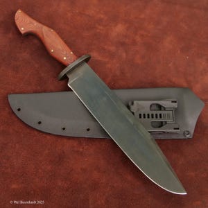 Könnte beinhalten: Ein großes Messer mit feststehender Klinge, dunkler Klinge und Holzgriff. Der Griff ist rotbraun mit Messingnieten. Das Messer liegt auf einer schwarzen Scheide.
