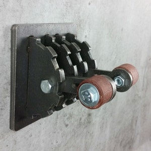 May include: A metal light switch with a unique industrial design. The switch has four gears and two wooden handles. The switch is mounted on a metal plate.