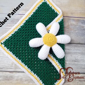 May include: Crocheted green square with white, yellow, and green border, and a white and yellow daisy. The words "Crochet Pattern" are in the upper left corner. The design is handmade.