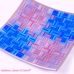 May include: A square glass dish with a woven pattern in shades of blue and pink. The dish is slightly curved and has a white border.