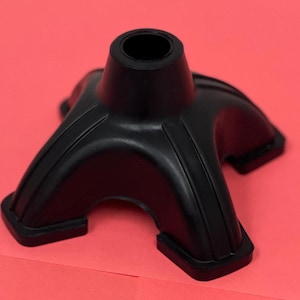May include: Black rubber cane tip with a four-pronged base. The base has a textured surface and a hole in the center.