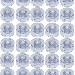 May include: A collection of transparent plastic sewing machine bobbins. Each bobbin has a circular design with a central spool and two outer discs. The bobbins are arranged in a grid pattern, showcasing their clear, functional design.