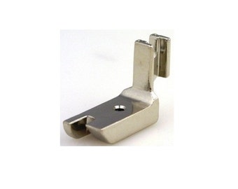 May include: A silver sewing machine foot with a small hole in the center and a raised edge on one side.