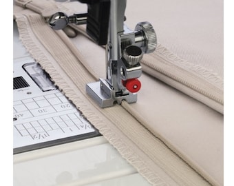 May include: A close-up of a sewing machine foot with a zipper foot attachment. The foot is made of metal and has a red knob. The zipper foot is being used to sew a zipper into a piece of fabric.