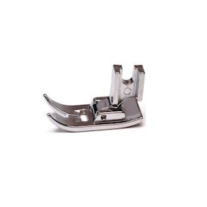 May include: A silver sewing machine foot with a curved needle plate and a raised metal guide.