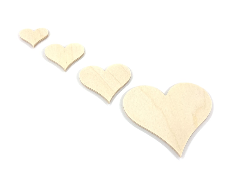 May include: Four wooden hearts of varying sizes, arranged in a row from smallest to largest, on a white background.