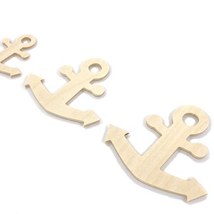 May include: Three unfinished wooden anchor shapes, arranged in a row, on a white background.