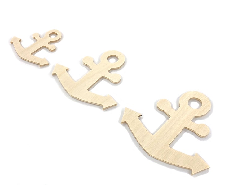 May include: Three unfinished wooden anchor shapes, arranged in a row, on a white background.