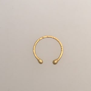 May include: A gold ring with a textured band and rounded ends.