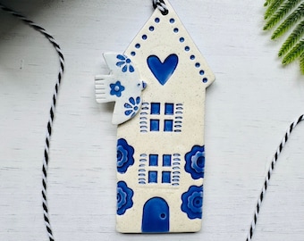handmade pale blue bird flying over a Dutch house ceramic ornament
