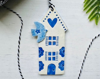 handmade blue bird flying over a Dutch house ceramic ornament