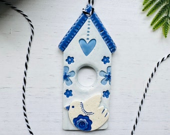 handmade perching bird on a Dutch house ceramic ornament