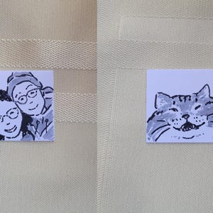 May include: Two small square drawings. One shows two people smiling, wearing glasses, and drawn in black and white. The other shows a smiling cat, also in black and white.