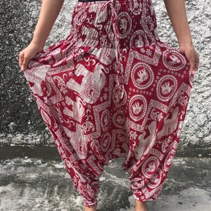 K&ouml;nnte beinhalten: Rote und wei&szlig;e gemusterte Hose mit Elefanten-Design. Die Hose hat einen Kordelzugbund und eine lockere, flie&szlig;ende Passform.