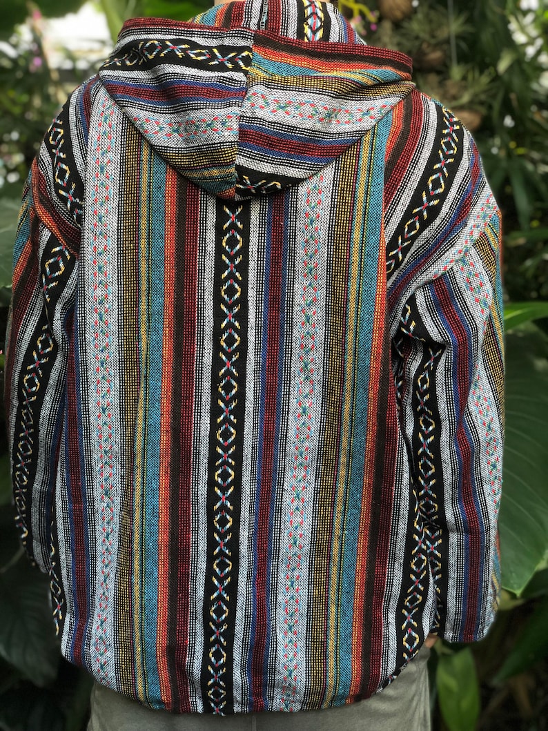 K&ouml;nnte beinhalten: Eine Kapuzenjacke mit einem farbenfrohen Streifenmuster. Die Jacke hat vertikale Streifen in verschiedenen Farben, darunter Rot, Blau, Gelb und Schwarz. Die Kapuze und die Schultern haben ein gemustertes Design. Die Jacke ist aus einem gewebten Stoff gefertigt.