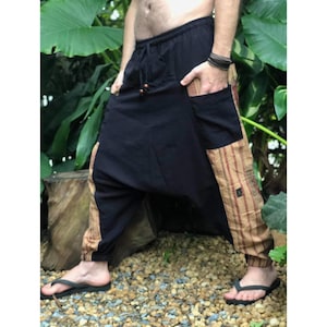 Puede incluir: Pantalones negros y marrones con estampado, cintura con cordón y un bolsillo grande en el lado derecho.