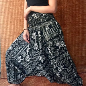 May include: Black and white patterned pants with an elephant design. The pants are loose fitting and have a wide leg.