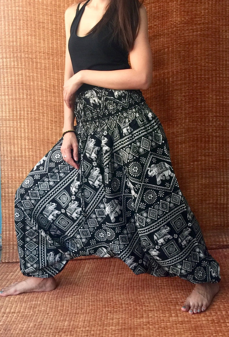 May include: Black and white patterned pants with an elephant design. The pants are loose fitting and have a wide leg.