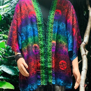 Peut inclure: Un kimono color&eacute; avec un d&eacute;grad&eacute; arc-en-ciel et des motifs de mandala. Le kimono a une bordure verte et noire le long de l'ouverture avant.