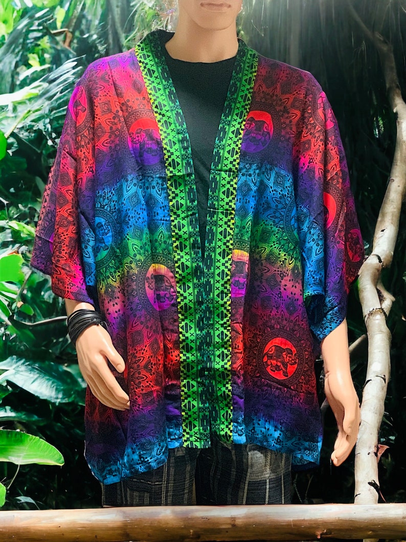 Peut inclure: Un kimono color&eacute; avec un d&eacute;grad&eacute; arc-en-ciel et des motifs de mandala. Le kimono a une bordure verte et noire le long de l'ouverture avant.