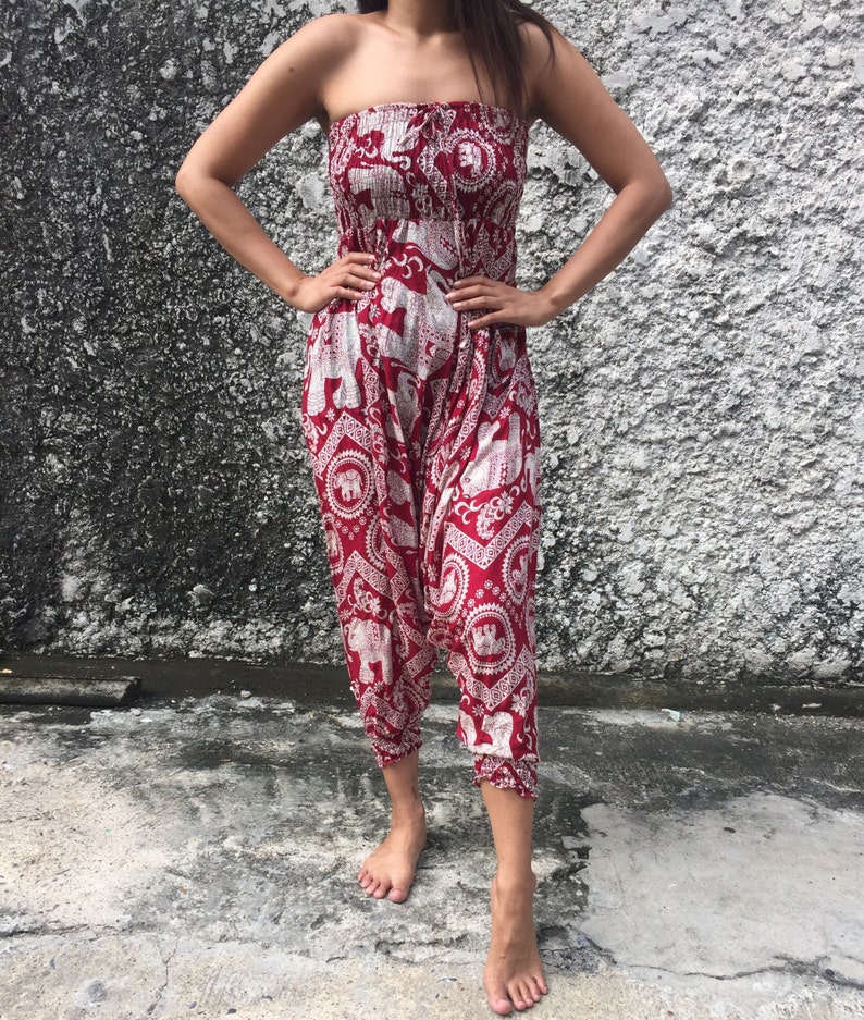 K&ouml;nnte beinhalten: Roter, tr&auml;gerloser Jumpsuit mit einem wei&szlig;en Elefantenmuster. Der Jumpsuit hat eine geraffte Taille und weite Beine.