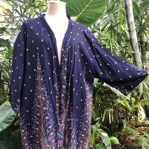 May include: A navy blue kimono with a peacock feather design and white polka dots. The kimono has a long, flowing silhouette and is made of a lightweight fabric.