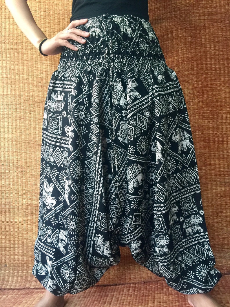 May include: Black and white patterned pants with an elephant design. The pants are loose fitting and have a wide leg.