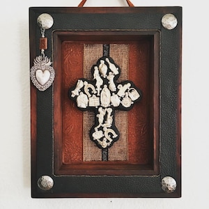 Catholic Mexican folk art shrine features wooden cross with milagros and vintage Sacred Heart charm and leather trim
