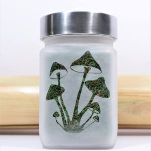 Twisted420Glass Magical Mushroom Etched Glass Stash Jar by Twisted420Glass features a psychedelic mushroom design, airtight seal and odor-proof technology, made of food-grade glass, perfect for stashing enthusiasts. A unique and fun mycology gift.