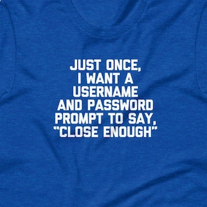 May include: A royal blue t-shirt with white text. The text reads: "JUST ONCE, I WANT A USERNAME AND PASSWORD PROMPT TO SAY, 'CLOSE ENOUGH'". The shirt is a short-sleeved crew neck.