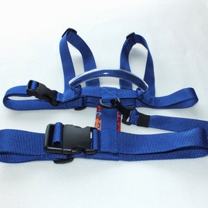 May include: Blue toddler harness with a clear plastic handle and adjustable straps. The harness has a buckle closure and is designed to help parents keep their children safe while walking.