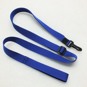 Peut inclure: Une sangle de caméra réglable bleue avec une boucle en plastique noire et un clip en métal.