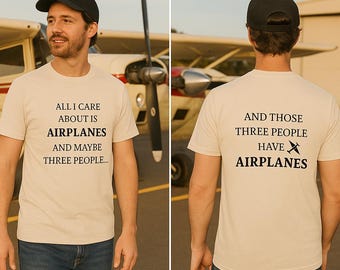 May include: Beige t-shirt with the text "ALL I CARE ABOUT IS AIRPLANES AND MAYBE THREE PEOPLE..." on the front. The back of the shirt reads "AND THOSE THREE PEOPLE HAVE AIRPLANES". The shirt is worn by a person in front of an airplane.