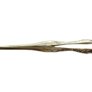 May include: A pair of silver-plated nutcrackers with an ornate design. The nutcrackers are closed and have a pointed tip.