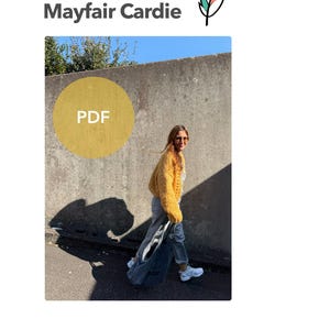 May include: The image features the text "Mayfair Cardie" and a logo. A person is wearing a yellow cardigan, gray pants, and white sneakers, carrying a gray bag. A yellow circle with "PDF" is in the image.