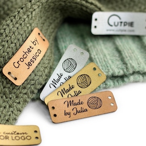 May include: Five leather labels with different text and designs. The labels are brown, gold, silver, and black. The text on the labels includes "Crochet by Jessica", "Made by Julia", "Made Julia", and "Cutpie".