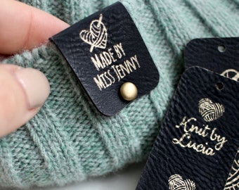 Custom black and gold tags for handmade items, size 2.5x1 inches with rivets for beanies