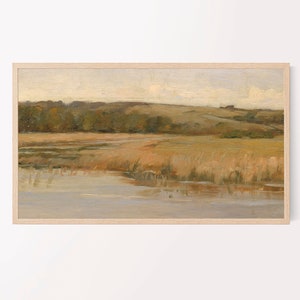 May include: A framed painting of a landscape with a lake in the foreground, a field of tall grass, and a line of trees in the background. The sky is a light blue with some clouds.