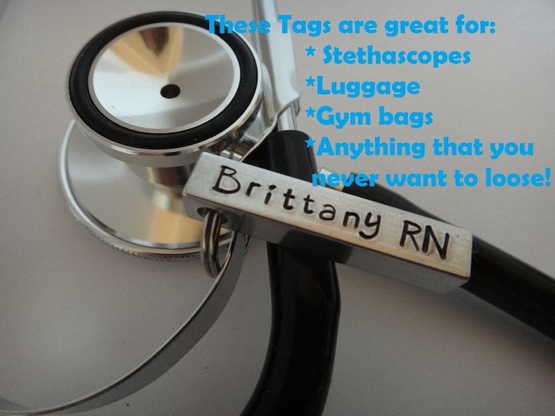 May include: A silver metal tag with the text "Brittany RN" engraved on it. The tag is attached to a stethoscope.