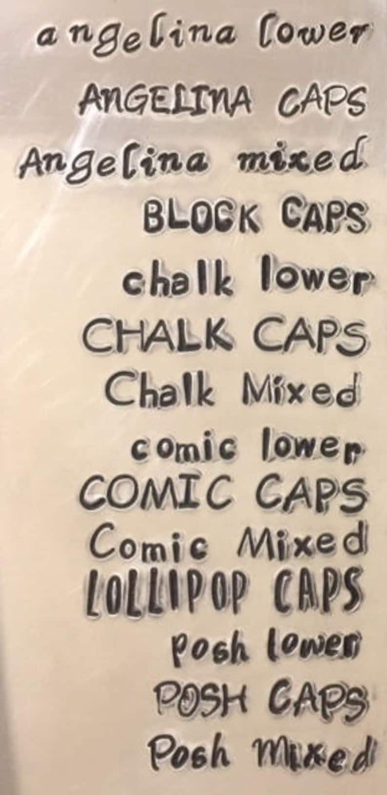 K&ouml;nnte beinhalten: Nahaufnahme einer durchsichtigen Plastikfolie mit verschiedenen Schriftarten darauf gedruckt. Der Text beinhaltet "angelina lower", "ANGELINA CAPS", "Angelina mixed", "BLOCK CAPS", "chalk lower", "CHALK CAPS", "Chalk Mixed", "comic lower", "COMIC CAPS", "Comic Mixed", "LOLLIPOP CAPS", "Posh lower", "POSH CAPS", und "Posh Mixed".