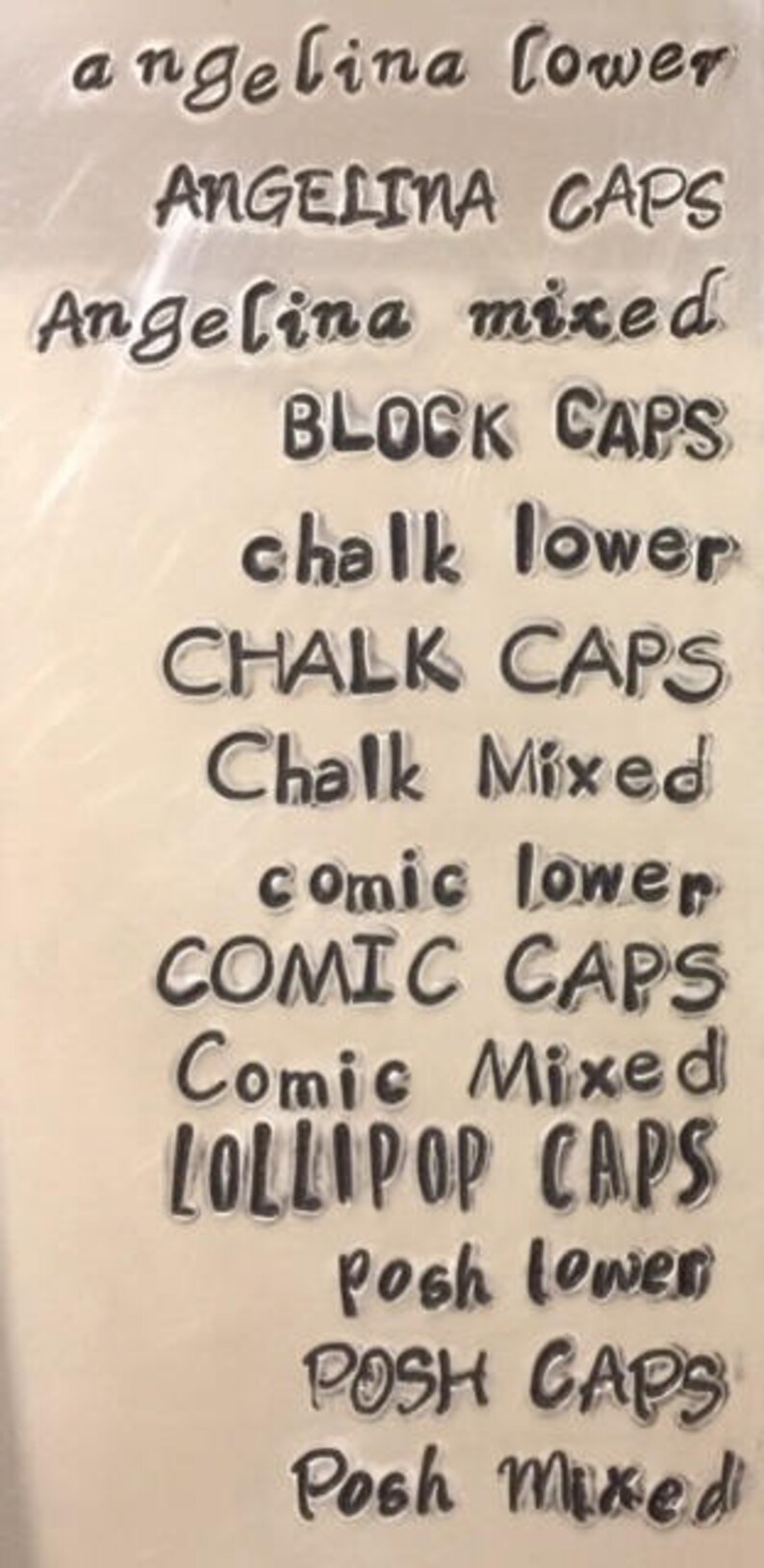 May include: A close-up of a sheet of clear plastic with various font styles printed on it. The text includes "angelina lower", "ANGELINA CAPS", "Angelina mixed", "BLOCK CAPS", "chalk lower", "CHALK CAPS", "Chalk Mixed", "comic lower", "COMIC CAPS", "Comic Mixed", "LOLLIPOP CAPS", "Posh lower", "POSH CAPS", and "Posh Mixed".
