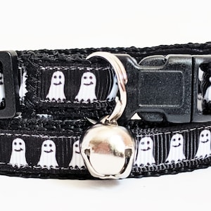 Puede incluir: Collar negro para gato con un patr&oacute;n repetido de fantasmas blancos sonrientes. El collar tiene una hebilla de pl&aacute;stico negro y una campana plateada. Un accesorio divertido y festivo para Halloween.