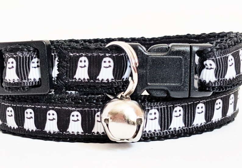 Puede incluir: Collar negro para gato con un patr&oacute;n repetido de fantasmas blancos sonrientes. El collar tiene una hebilla de pl&aacute;stico negro y una campana plateada. Un accesorio divertido y festivo para Halloween.