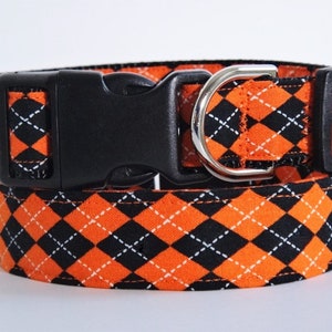 May include: Orange and black argyle dog collar with a black plastic buckle and a silver D-ring.