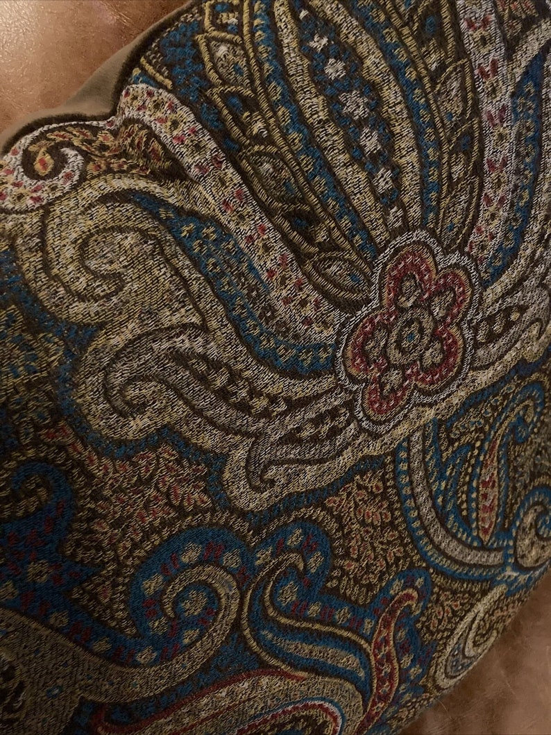 Puede incluir: Un coj&iacute;n de color marr&oacute;n, azul y crema con un patr&oacute;n de paisley y un dise&ntilde;o floral en el centro.