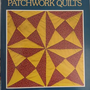 May include: A book titled "Easy-to-Make Patchwork Quilts" by Rita Weiss. The cover features a quilt design with yellow and burgundy fabric. The book includes step-by-step instructions and full-size templates for 12 quilts.