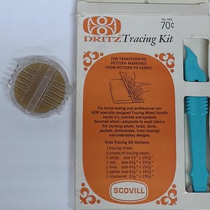 May include: A Dritz Tracing Kit for transferring pattern markings. The kit includes a tracing wheel, tracing paper, and blue plastic tools. The packaging is white and orange with text and illustrations. The kit is designed for home sewing and professional use.