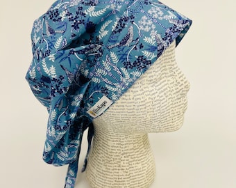 May include: A blue and white patterned surgical scrub hat with a tie at the back. The hat has a small yellow label that says "ImKaps".